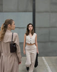 Pantalon Droit Femme Beige Confortable pour Style Décontracté - Sapiato: Deux femmes en conversation, l'une en pantalon droit beige, illustrant une mode décontractée.