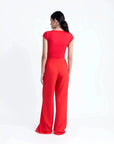 Vue arrière d'un modèle dans un pantalon palazzo rouge femme, soulignant la taille haute et la coupe flottante.