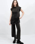 Femme debout dans un ensemble style tunique et pantalon large en tricot, portant un haut sans manche femme, affichant un look moderne et tendance.