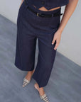 Détail du gilet court sans manche femme en bleu indigo chic, avec un pantalon ajusté et ceinture noire, parfait pour un look moderne.
