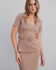 Femme posant avec un haut chic femme taupe, mettant en valeur la ceinture effet écaille.