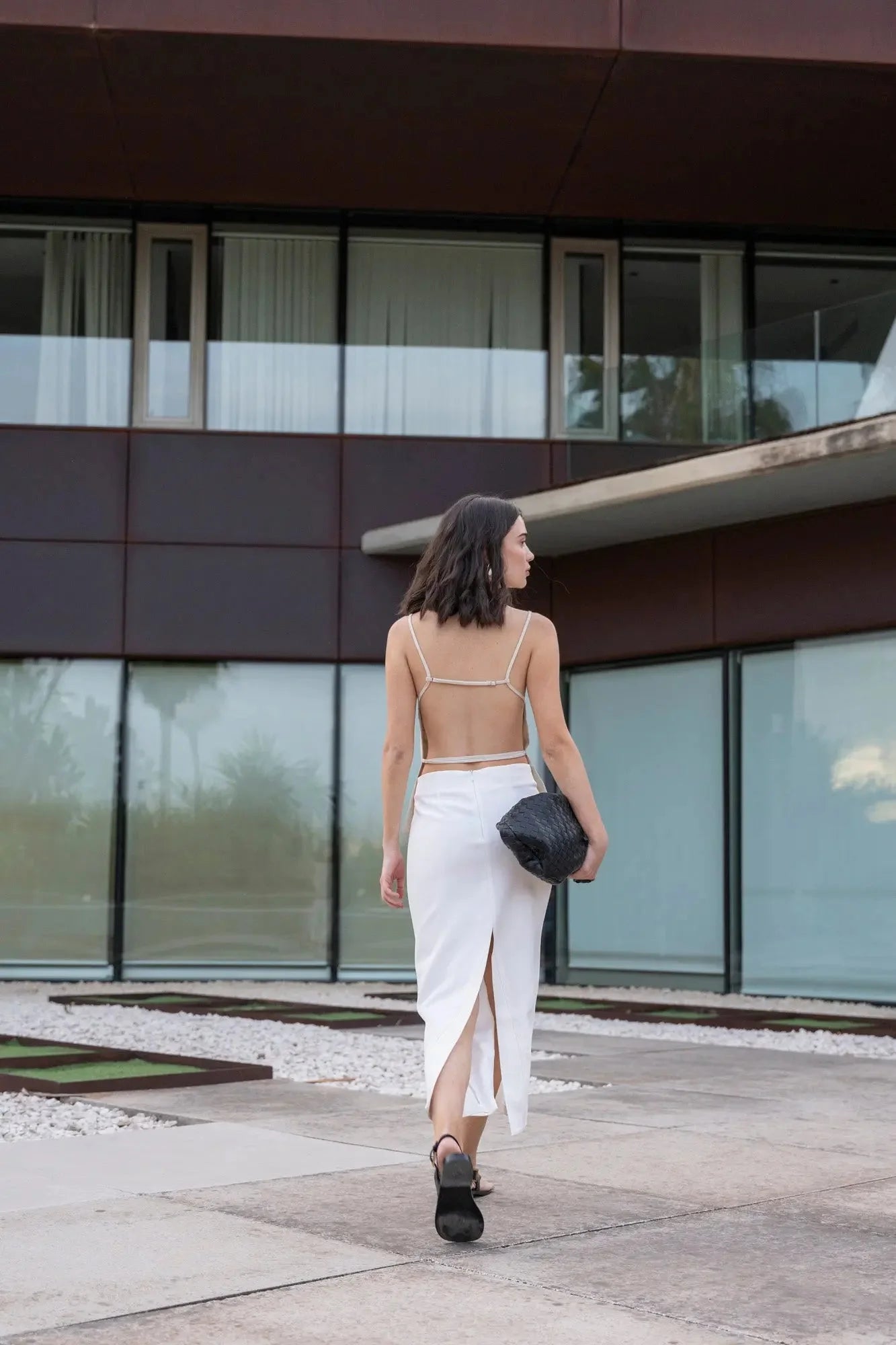 Femme marchant avec style dans une jupe blanche longue femme, soulignant le confort et la liberté de mouvement.