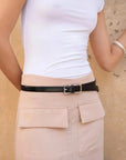 Femme portant la jupe cargo femme beige avec une ceinture noire, montrant son style chic.