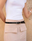 Femme portant la jupe cargo femme beige avec une ceinture noire, montrant son style chic.