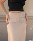 Zoom sur la jupe cargo femme beige avec des poches pratiques, portée avec un haut noir.