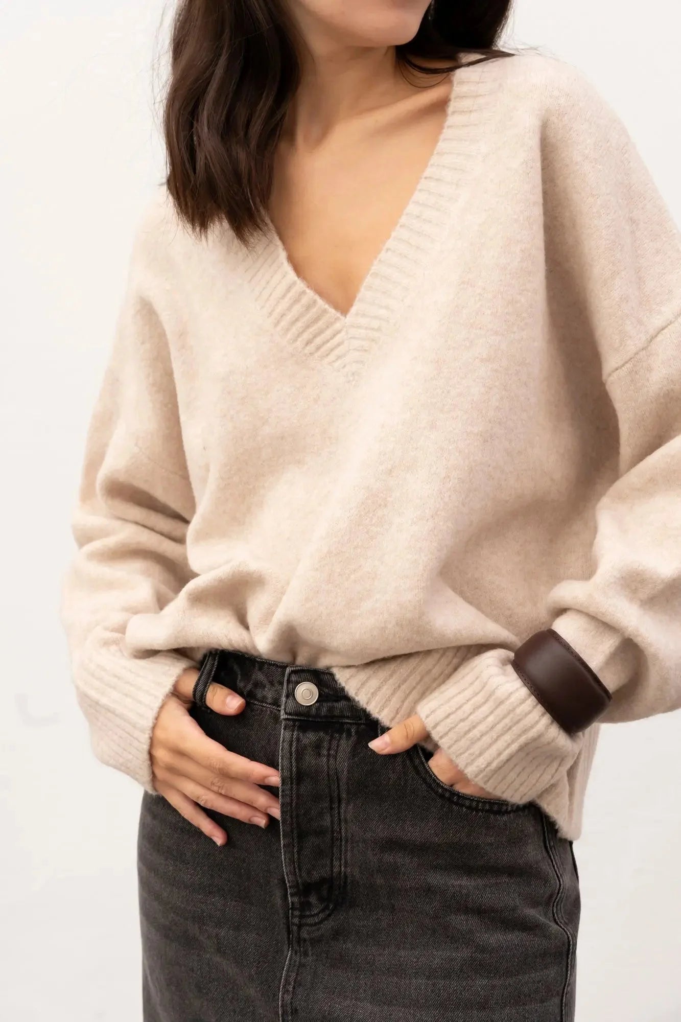 Femme portant une jupe midi polyvalente en denim avec fente et pull beige