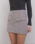 Zoom sur la jupe-short à carreaux femme taille haute, soulignant les poches et le motif stylé du skort.