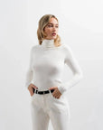 Look décontracté avec un pull col roulé femme en blanc, une pièce essentielle pour l'hiver, faisant partie des indispensables de la garde-robe d’hiver.