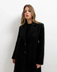 Manteau ajusté en laine pour femme, modèle noir, avec un style chic et intemporel pour l'hiver. Manteau femme chic hiver.