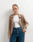 Femme stylée avec un trench coat femme, en marron clair, associé à un haut blanc, affichant une allure casual élégante.