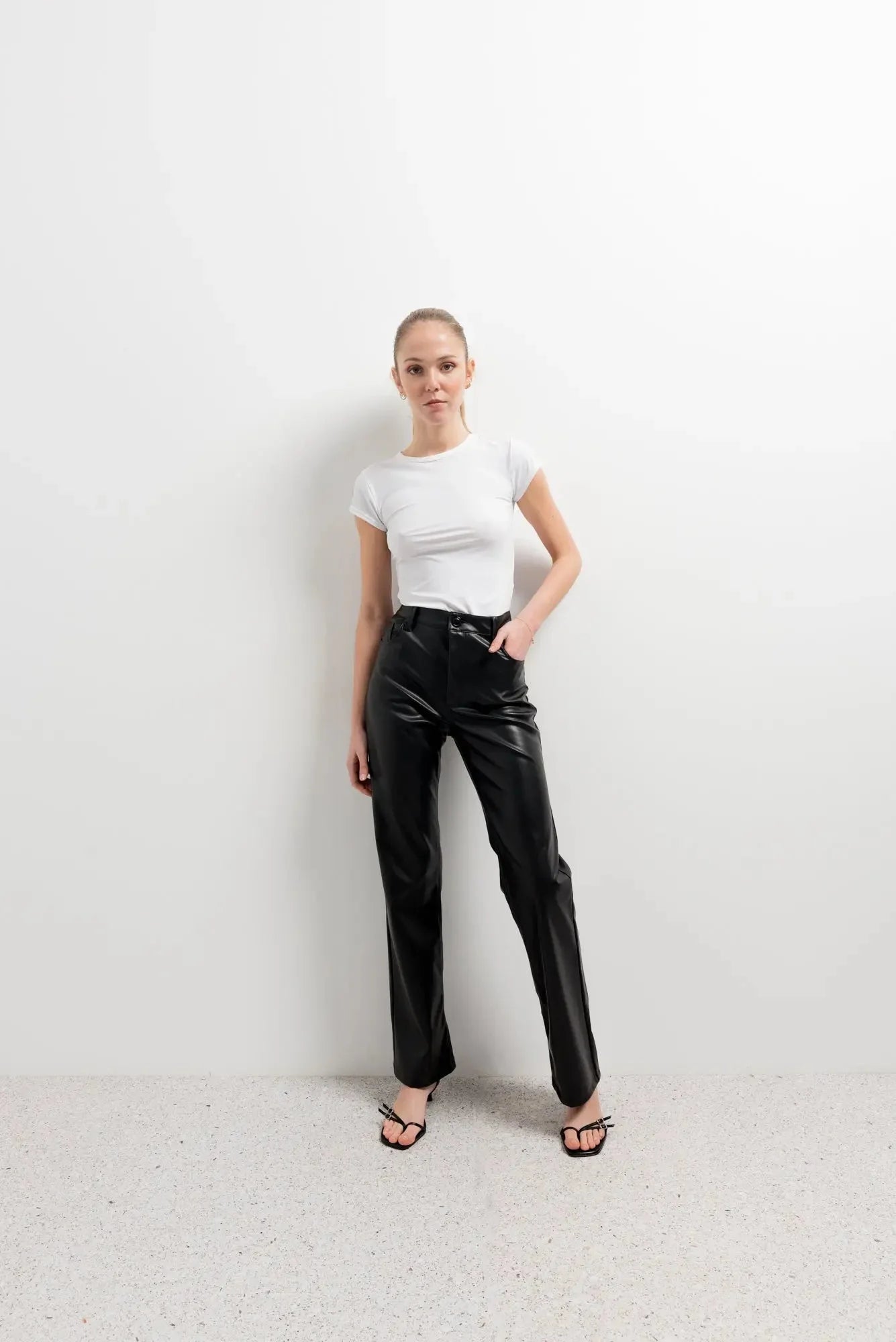 Femme portant un pantalon effet cuir noir élégant en pantalon effet cuir et effet cuir