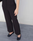 Détail du pantalon à pince femme noir, mettant en valeur sa coupe moderne et élégante, parfaite pour le bureau.