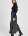 Femme portant un pantalon large taille haute femme gris, mettant en avant une silhouette moderne.