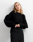 Pull Laine Femme Oversize à Manches Ballon - Femme affichant un pull laine femme noir, style moderne et audacieux.
