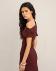 Femme tournant avec une robe asymétrique chic bordeaux – Coupe élégante et polyvalente en polyester, alliant confort et style.