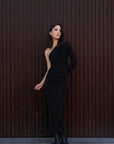Modèle en robe asymétrique une manche noire, capturant le style chic et la sophistication adaptée aux réceptions et aux soirées.