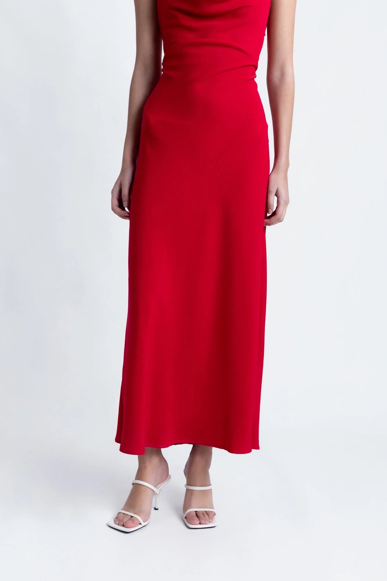 Robe longue rouge dos nu avec col bénitier et sandales blanches à talons hauts