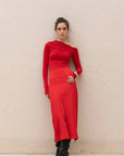 Femme en jupe rouge longue fendue chic à taille haute, ajoutant une touche de sophistication à son look avec une fente avant séduisante.