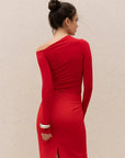 Femme de dos dans une jupe rouge longue fendue chic à taille haute, soulignant la silhouette élégante avec une attitude moderne.