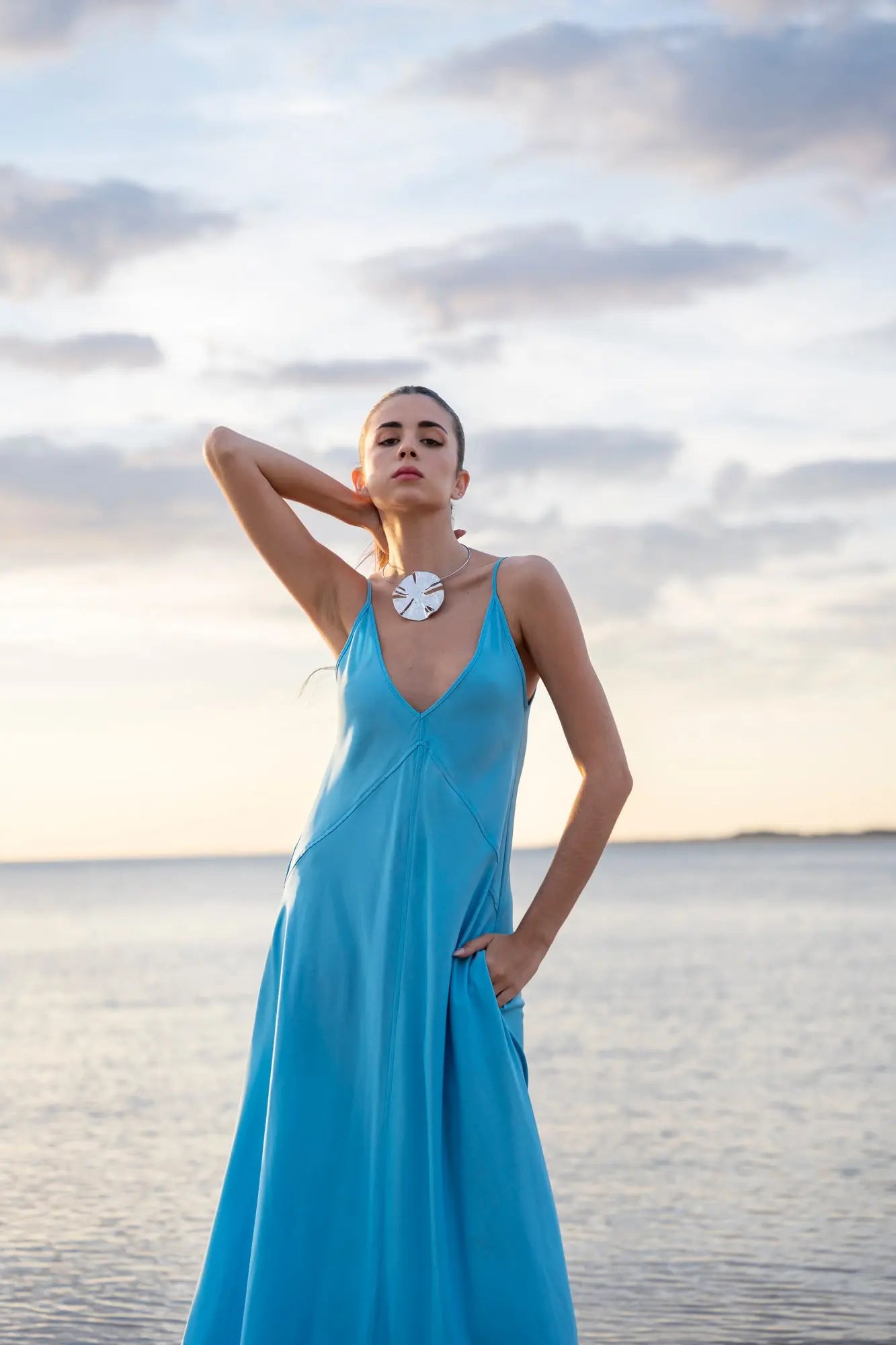Robe midi à bretelles fines, vue en mouvement sur fond de plage.o