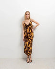 Modèle en robe imprimé tropical midi floral marron et jaune, affichant un style chic et décontracté.