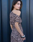 Femme affichant un look chic en robe midi léopard à motif animalier, une belle option pour une robe léopard longue.