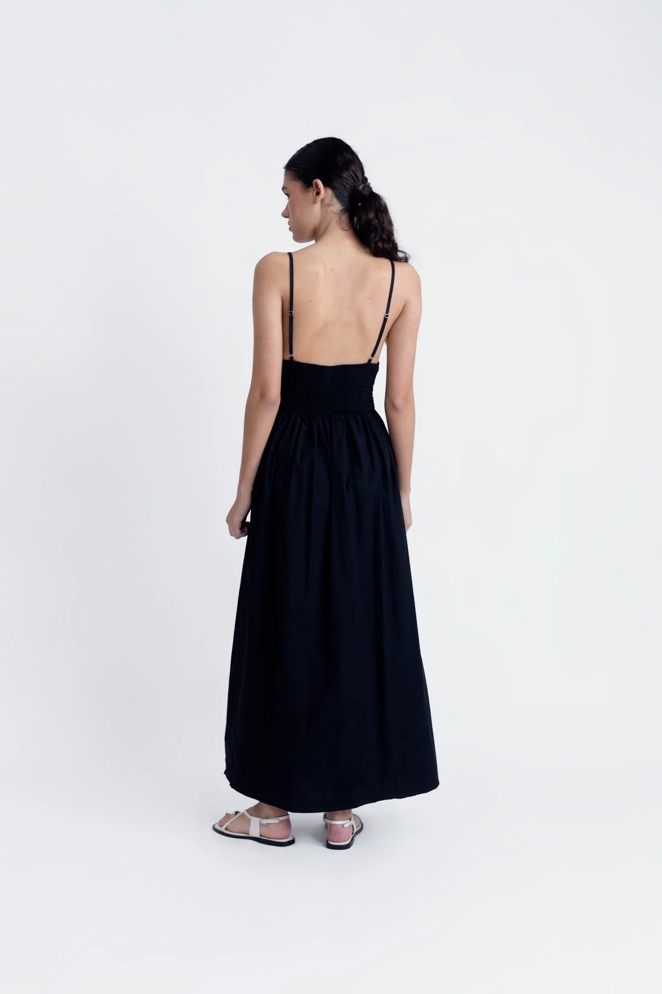 Robe midi noire à fines bretelles avec jupe fluide et sandales plates