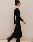 Silhouette de femme marchant avec une robe noire longue femme élégante, fente midi visible.