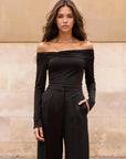 Modèle portant le Body Femme Noir Manche Longue À Épaules Dénudées, capturant un look intemporel et avant-gardiste.