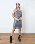 Robe Paillette Femme Courte Argentée à Fines Bretelles – Élégance Brillante Pour Vos Soirées, portée avec des bottines noires, parfaite pour un look glam.