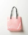 Sac à main en vinyle rose translucide avec poignées noires, idéal pour utilisation quotidienne