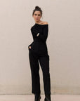 Jumpsuit asymétrique noir à manches longues avec bottines à talons pour femme