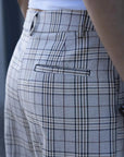 Gros plan sur le pantalon femme carreaux à motif beige, avec une coupe stylée et des détails élégants, montrant la qualité du design. Pantalon femme carreaux.
