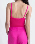 Femme vue de dos avec un pantalon femme mode lin rose fuchsia taille haute fluide et un top en maille fuchsia.