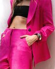 Détail d'un tailleur pantalon en lin rose fuchsia, blazer rose fuchsia femme, avec top noir.