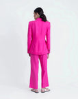 Femme vue de dos portant un blazer et un pantalon femme mode lin rose fuchsia taille haute fluide.