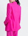 Détail sur le dos d'un tailleur pantalon en lin rose fuchsia, blazer rose fuchsia femme, avec coupe raffinée.