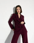 La model dans un blazer femme bordeaux double boutonnage croisé, montrant une allure élégante en pose.