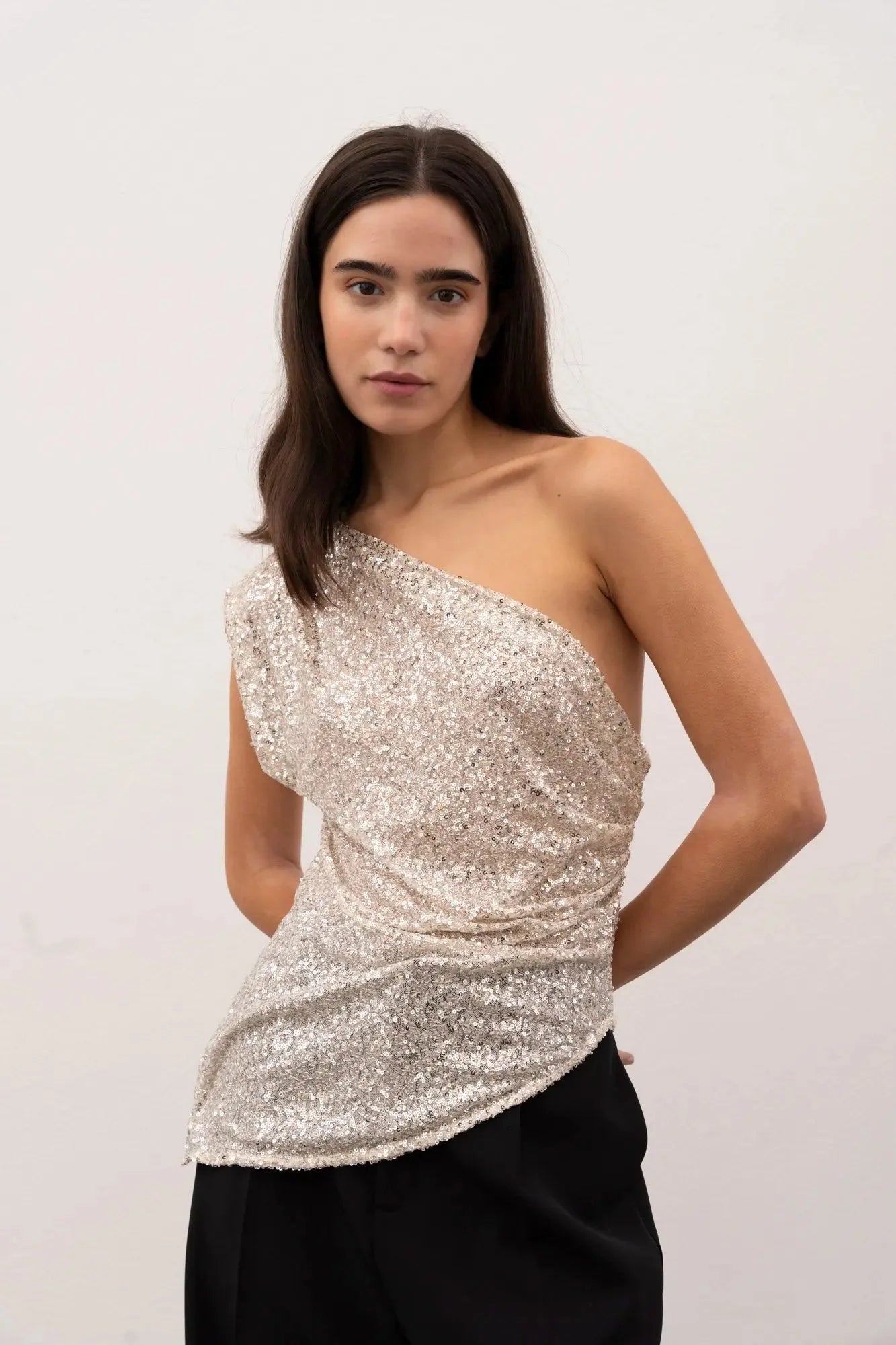 Top asymétrique aux plus paillettes argentées avec détail drapé pour un look élégant