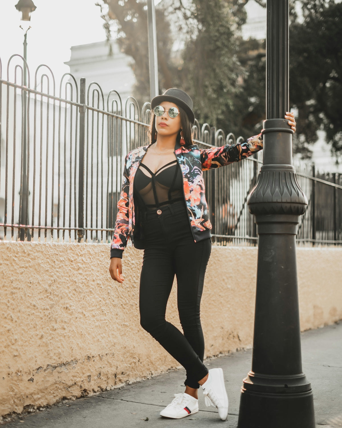 woman in black pants and black and red floral long sleeve shirt standing on brown sand