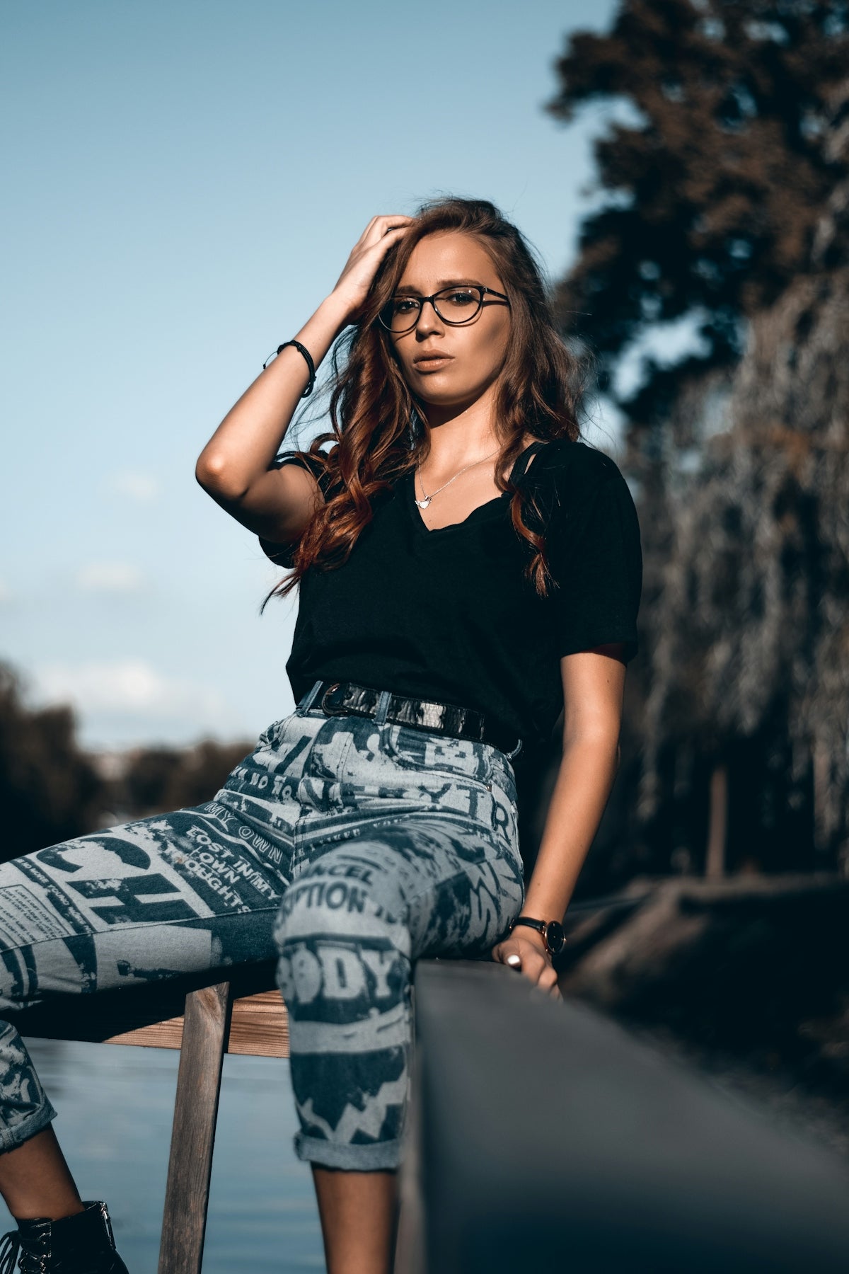 woman in black t-shirt and white and black pants sitting on concrete pavement