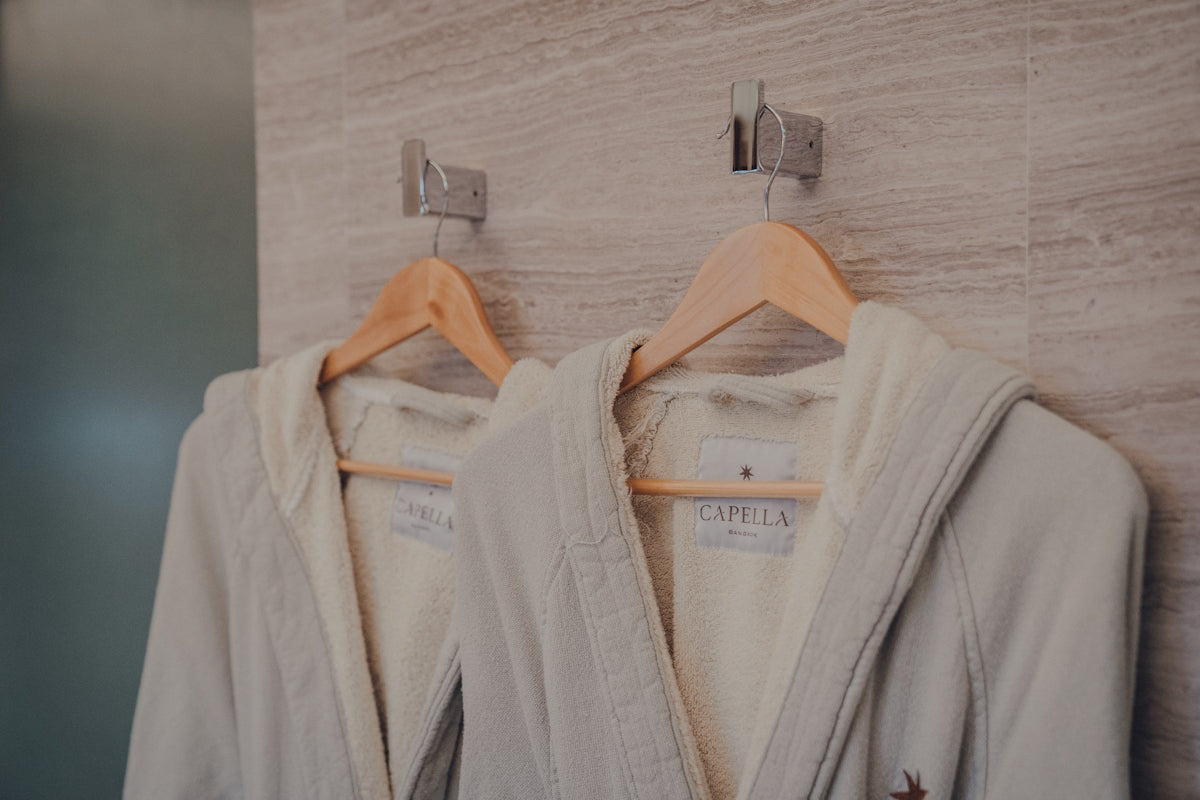 a robe hanging on a wall next to a coat rack