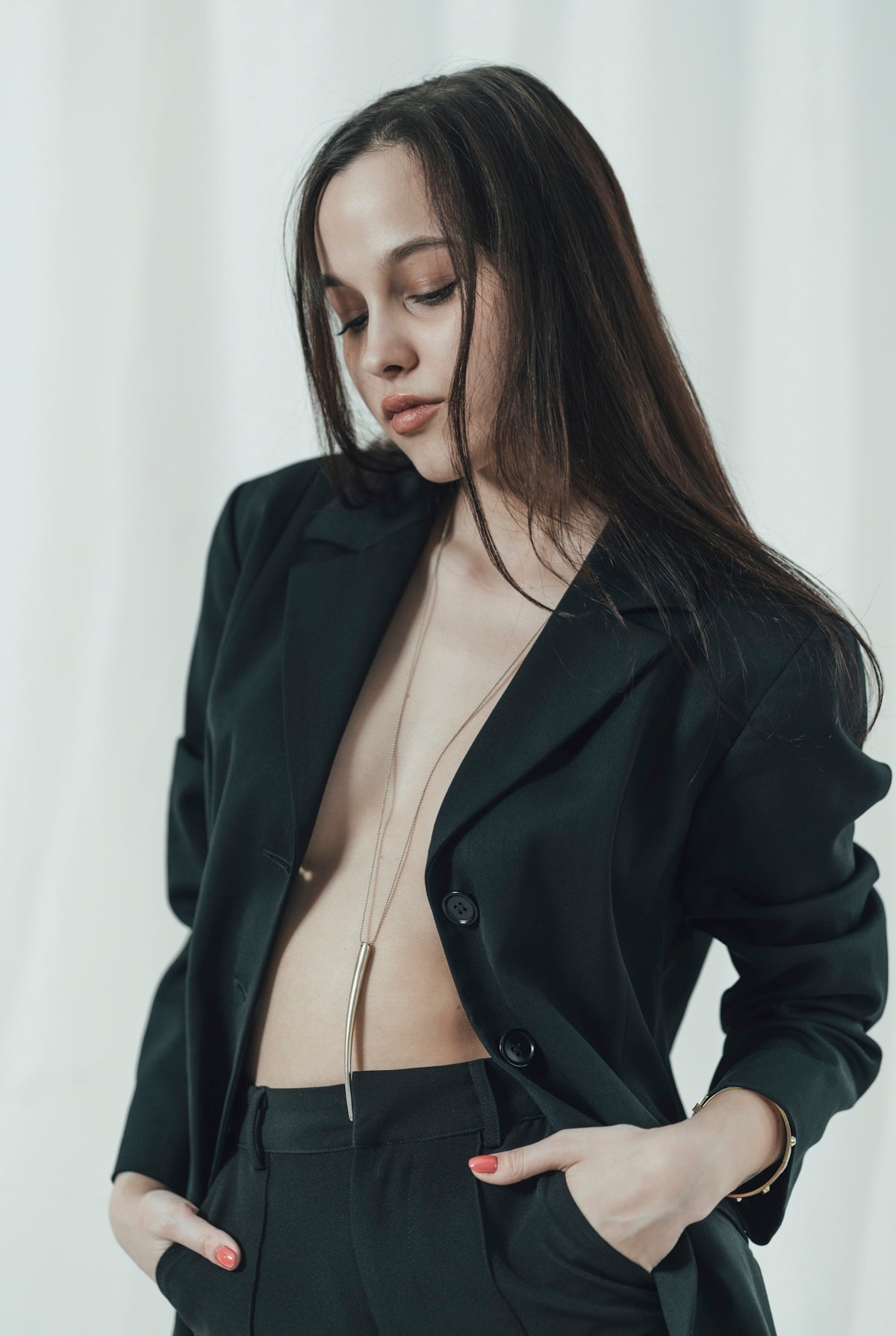 a woman in a black suit with her hands on her hips