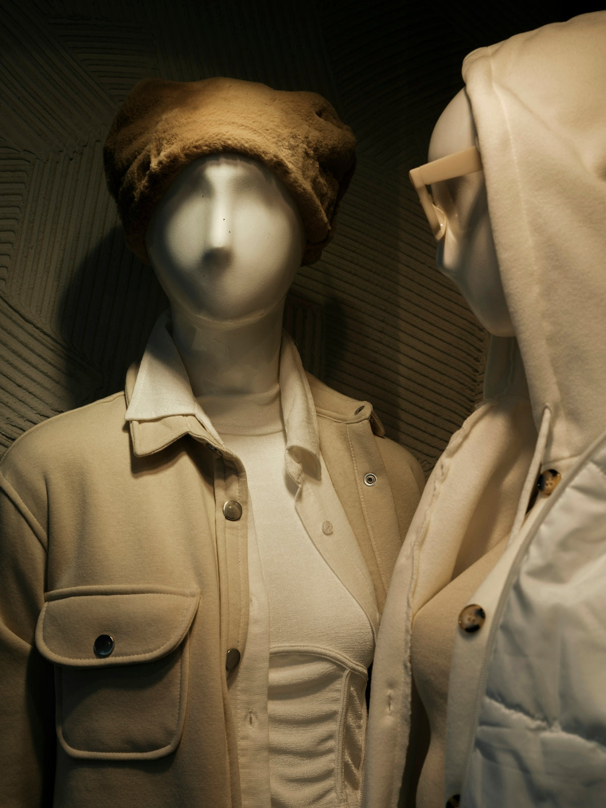 two mannequins dressed in coats and hats