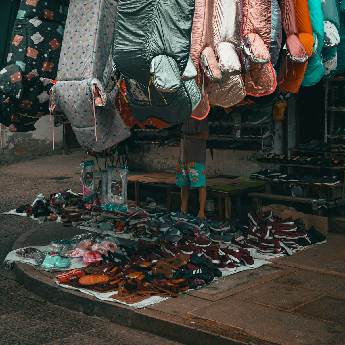 a person standing in front of a pile of shoes