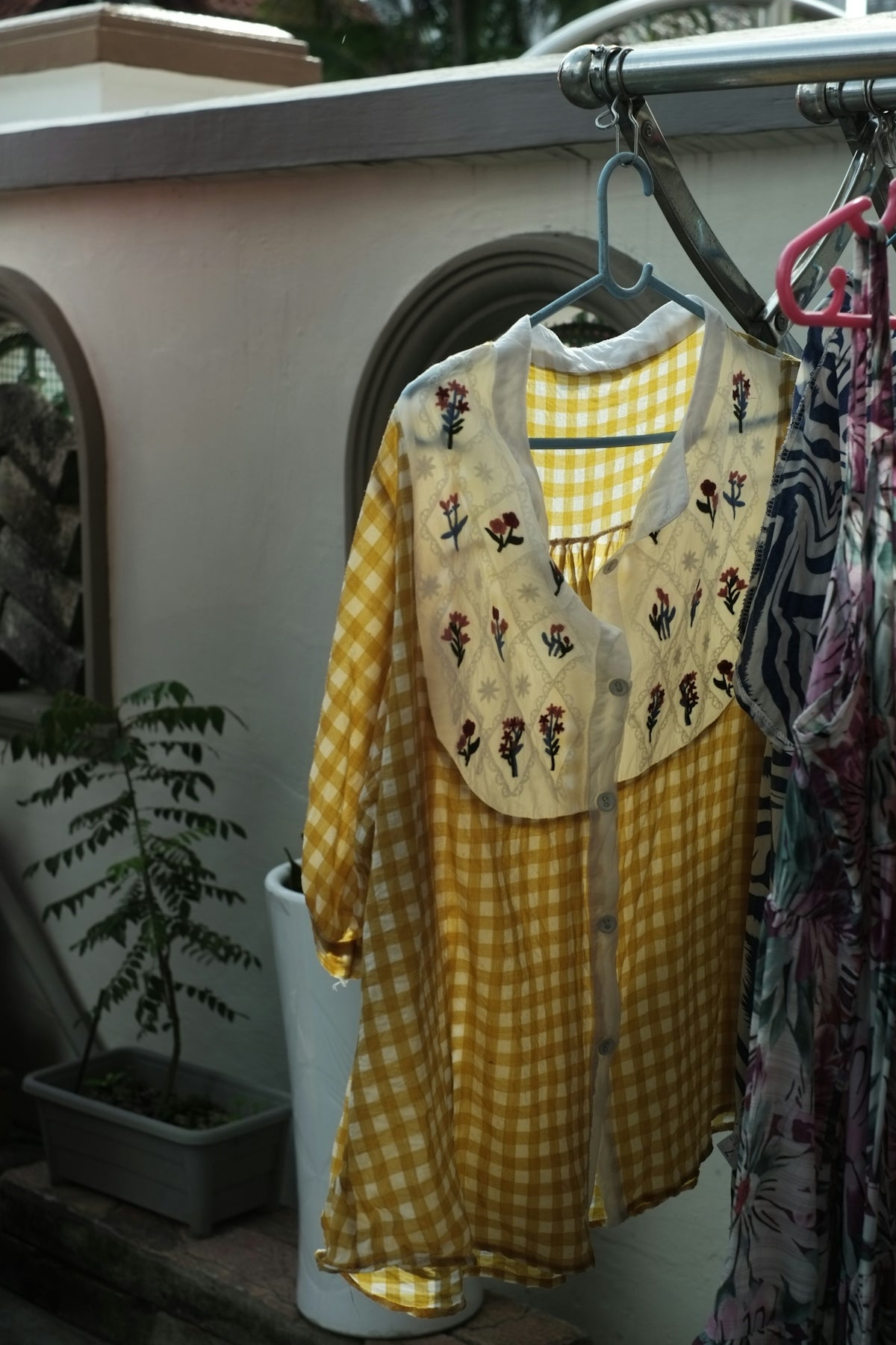 a yellow and white dress hanging on a clothes rack
