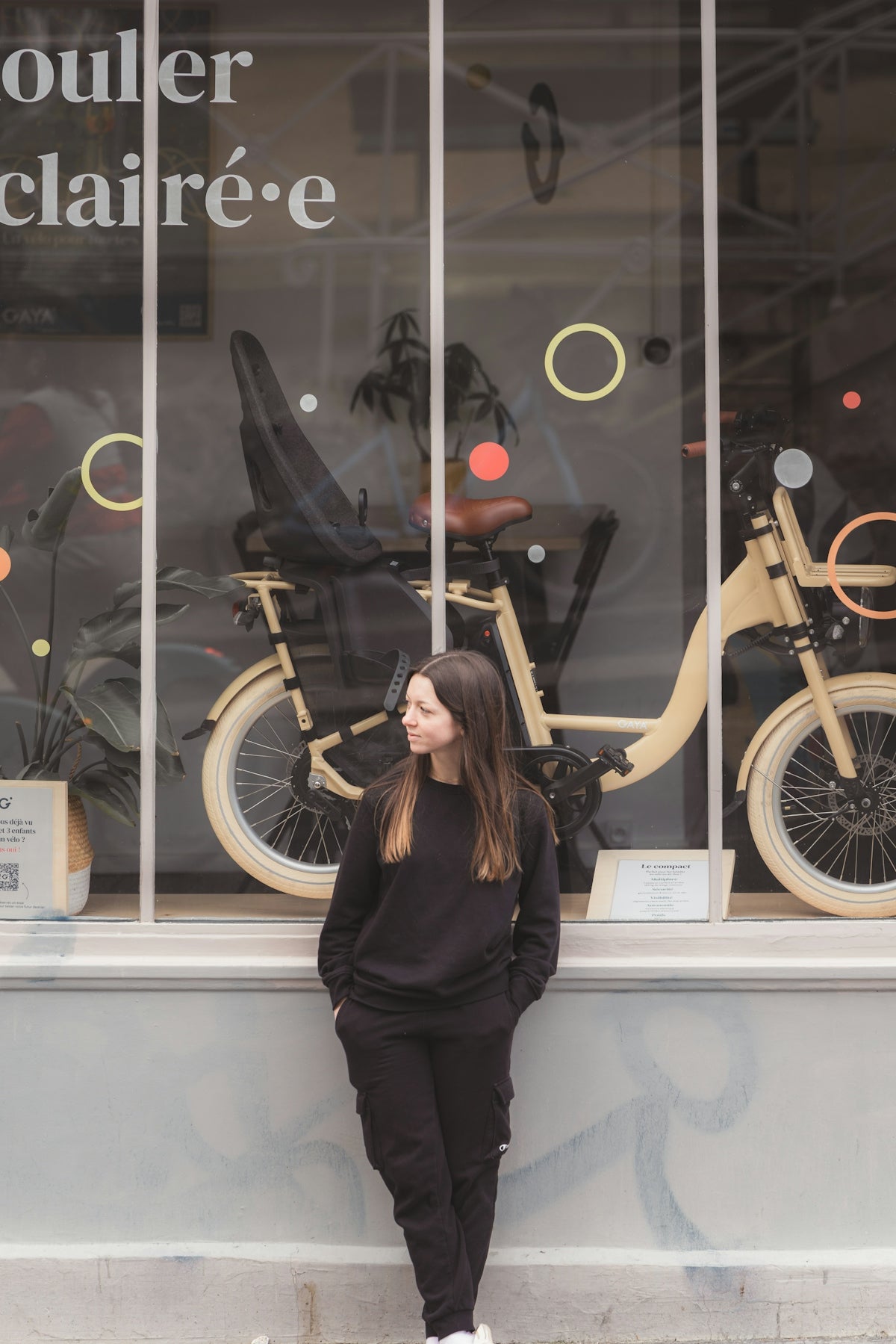 a woman standing in front of a bike shop
