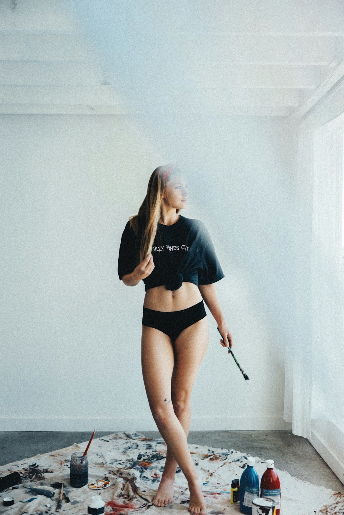 A woman in a bikini standing on a messy floor