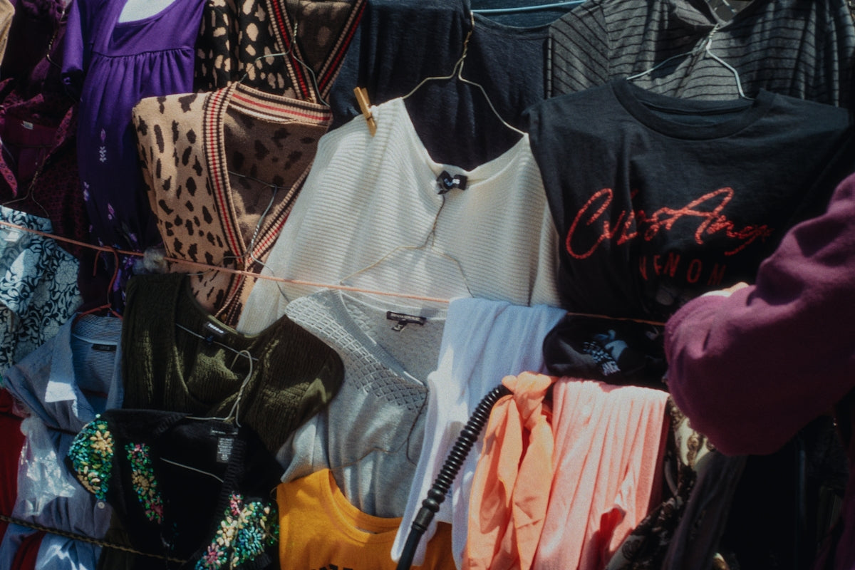 Clothes hang on a rack in a clothing store.