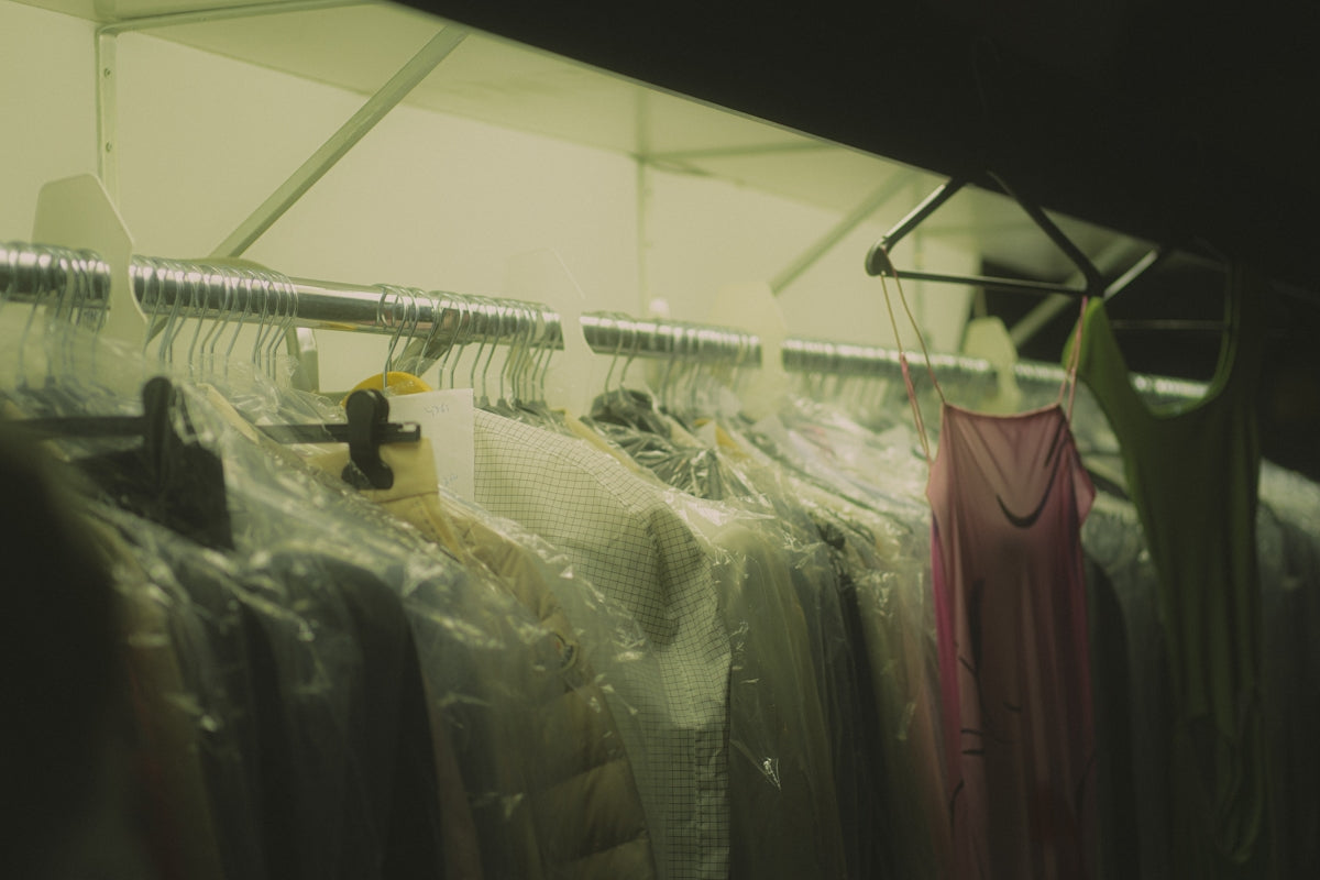 Clothes hanging on a rack in plastic covers.